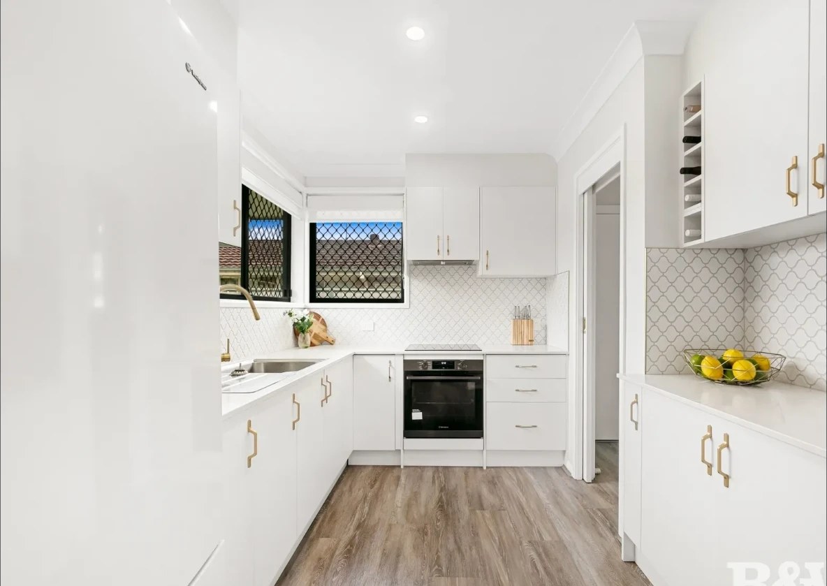Woy Woy House kitchen in white with brass handles